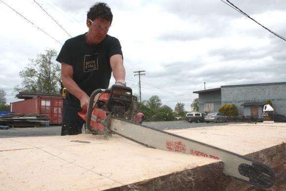 Andrew Vallee carefully cuts one of the spruce slabs that will be made into the Sealaska Corp. Conference Table.